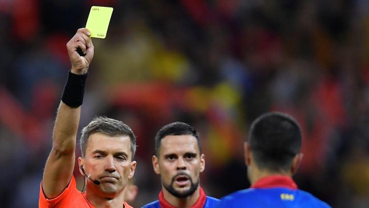 Estonian referee Kristo Tohver shows a card
